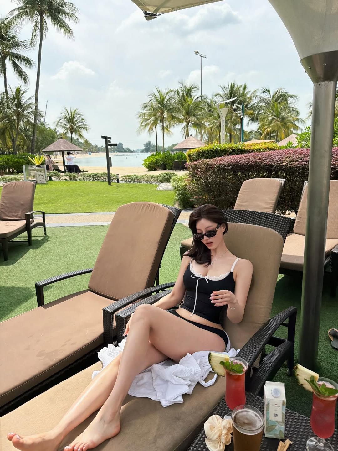 해변과 바다 풍경 속에서 강조되는 블랙 스윔웨어 스타일